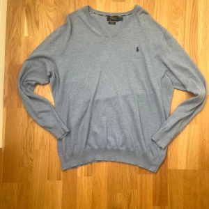 Ljusblå v-ringad tröja från Polo Ralph Lauren - Säljer en ljusblå v-ringad tröja från Polo Ralph Lauren i pima bomull. Tröjan har lång ärm, slim fit passform och den klassiska broderade loggan på bröstet. Perfekt för dig som gillar stilrena och bekväma plagg.