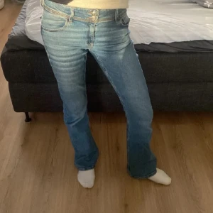 Lågmidjade bootcut jeans  - Supersnygga blåa jeans med knappar på fickorna där bak från Gina tricot Young. Man kan justera midjan själv (se sista bilden) 🥰 storlek 170 (passar som XS)