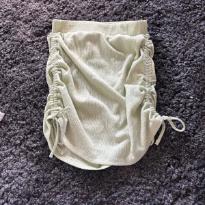 Ljusgrön ribbad kjol från NLY Trend - Supersöt ljusgrön kjol från NLY Trend i ribbat material. Kjolen har dragsko och knyt på sidorna som ger en snygg rynkad effekt. Perfekt att styla med en enkel topp för en trendig look.