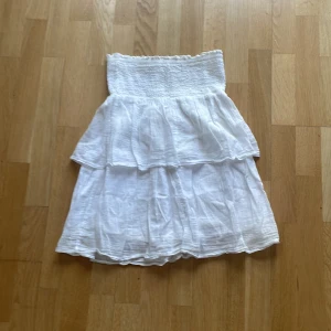 Vit tube klänning från Gina Tricot - Säljer en söt vit klänning från Gina Tricot med volangdetaljer. Klänningen är luftig och har en kort längd, perfekt för varma dagar. Passar dig som gillar en enkel men trendig stil. Och perfekt för stranden 🤍