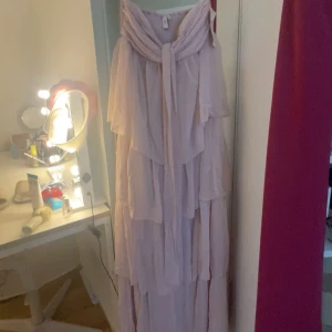 Ljusrosa balklänning  - Säljer en ljusrosa balklänning från Nelly med flera lager volang och knyt vid halsen. Klänningen är axelbandslös och har en luftig, flowy passform. Den är oanvänd med prislapp eftersom jag ångra min köp. ( pris kan diskuteras💕)