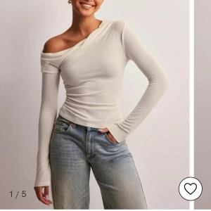 One shoulder topp  - En super fin topp från Nelly i creme färg. På min bild ser den mer gul ut än i verkligheten! Aldrig använt därav säljer jag den. Den är i storlek S men skulle säga att den passar en M. 