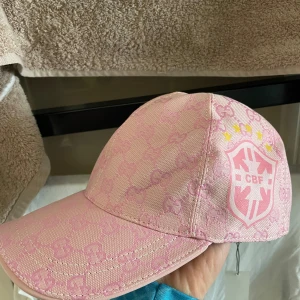 Gucci Brasilien keps  - Säljer denna riktigt feta custom rosa Gucci kepsen med Brasilien logga på sidan. NY MED TAGS ALDRIG ANVÄND. Justerbar storlek. Perfekt till sommaren. Kan tänka mig gå ner i pris vid snabb affär 🌸