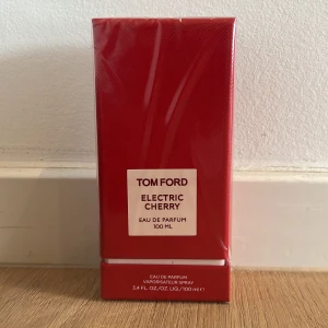 Tom Ford Electric Cherry EdP 100ml - Tom Ford Electric Cherry Eau de Parfum i en snygg röd kartong på 100 ml. Parfymen har en lyxig och modern design med tydlig etikett framtill. Perfekt för dig som gillar exklusiva dofter och vill sticka ut med en fruktig och djärv parfym.