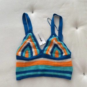 Färgglad virkad linnetopp Gina Tricot - Superfin virkad linnetopp från Gina Tricot i blått, orange, turkost och vitt. Toppen har breda axelband, coolt mönster med ränder och triangelformade kupor. Somrig vibe och fin passform!💙🩵
