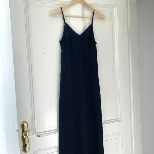 Klänning NAKD - Slip on-klänning med struktur i tyget. Midi-längd. Nyskick förutom att lappen i nacken är bortklippt pga att den skavde. Använd 1 gång