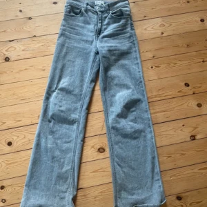 Gråa wide jeans från H&M - Snygga grå jeans från H&M i modell med breda ben och jeansen har hög midja 