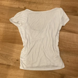Vit basic rygglös T-shirt - Enkel perfekt vit rygglös T-shirt i storlek M. Perfekt nu inför sommaren och det varma vädret. 