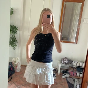 Svart ribbad linnetopp - En svart, tight och ribbad linnetopp med rund halsringning och ärmlös design. Perfekt basic-plagg som är enkel att matcha och har en clean look. Snygg passform som sitter nära kroppen och funkar året runt. Men perfekt nu till sommaren när man har mycket färglagda kjolar, naglar och smycken att matcha till!