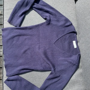 Mörkblå ribbad tröja från Primark - Säljer en mörkblå ribbad tröja från Primark i storlek S. Tröjan har v-ringning och långa ärmar, materialet är mjukt och stretchigt!