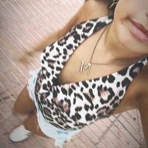 Leopardmönstrad body med öppen rygg - Säljer en snygg leopardmönstrad body med djup v-ringning och öppen rygg. Toppen är ärmlös och har tunna axelband som går runt nacken. Perfekt för dig som vill sticka ut med ett trendigt djurmönster och cool passform. 💌Köparen står för frakten!