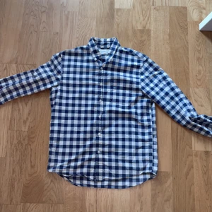 Rutig skjorta från Ralph Lauren M - Snygg rutig skjorta från Denim & Supply Ralph Lauren i blått och vitt. Klassisk passform med lång ärm, bröstficka och knappar hela vägen. Tillverkad i mjuk bomull, perfekt för en chill och stilren look. Mitt pris 250kr nypris 2000-2500kr