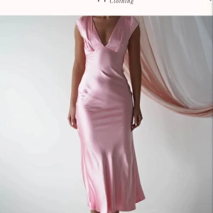 Ljusrosa långklänning i satin - Supersnygg ljusrosa långklänning i glansigt satinmaterial med djup v-ringning och korta ärmar. Klänningen har en figurnära passform. Perfekt för bal eller finmiddag. Enkel men elegant look som verkligen sticker ut. Från Oh Hello Clothing, helt slutsåld. Något mindre i storleken. 😊