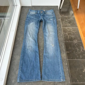 Y2k jeans med slitningar  - Så så snygga bootcut, lågmidjade jeans. Två knappar fram och snygga fickor bak. Coola slitningar. Innerbenslängd: ca 85 cm Midjemått: ca 42 cm midjehöjd: ca 22 cm 💕