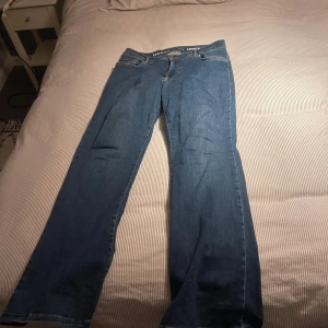 Lågmidjade bootcut jeans - Säljer ett par mörkblåa jeans som är lågmidjade, har använts max 1-2 gånger men säljer pågrund av att jag har för många andra som jag gillar mer. Dem sitter stretchiga så passar från M-Xxl. Super super sköna att ha en helt vanlig dag med passar till någon fin blus också. Storlek L, längd 31. Passar perfekt på mig som är 168. Nyinköpta för 499 