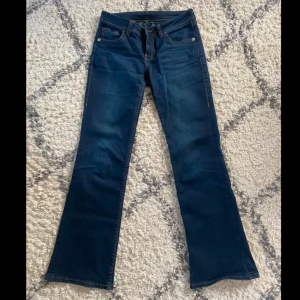 Mörkblå bootcut lågmidjade jeans från H&M - Mörkblå, lågmidjade och utsvängda jeans från Divided, H&M. Jeansen är i fint skick och har sömmar som detalj på bakfickorna.💙