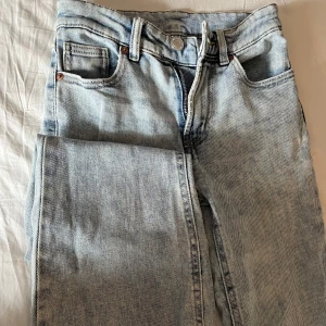 Ljusblå jeans med bootcut - Snygga ljusblå jeans med bootcut-stil och klassisk femficksdesign. De har en dragkedja och knapp framtill. Avklippta längst ner. Vet inte var de är ifrån då de är köpta här på plick, passar de som har 32/34