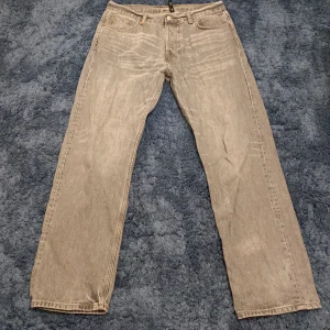 Grå jeans från Weekday - Säljer ett par grå jeans från Weekday i modellen Space Relaxed Straight. De har en klassisk femficksdesign och är tillverkade i bomull. Perfekta för en avslappnad stil med en rak passform.