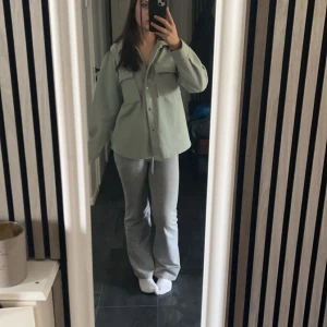 Pastellgrön kappa från Gina Tricot - Säljer en stilren pastellgrön kappa från Gina Tricot. Jackan har en avslappnad passform med knappar framtill och två stora bröstfickor. Perfekt för lager-på-lager under vår och höst. Pris kan diskuteras 