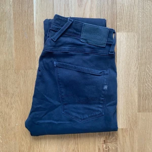 Replay anbass - Snygga svarta jeans från Replay med en klassisk femficksdesign. De har en knapp och dragkedja framtill samt en diskret Replay-logga på fickan. Perfekta för en stilren look.