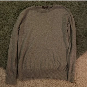 Stickad grå Ströms tröja i bomull och kashmir - Säljer en supermjuk och stilren grå tröja i 95% bomull och 5% kashmir. Perfekt för både höst och vinter med sin långärmade design och ribbade kanter. Passar till alla tillfällen när du vill känna dig bekväm och snygg. Hör av dig vid intresse!