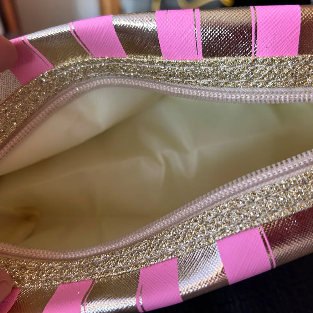 Necessär från Victoria's Secret i guld och rosa med avtagbart handtag och dragkedja. Mått: 10 x 20 cm. Oanvänd.. Laukut & Käsilaukut.