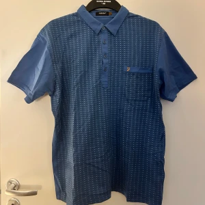 Blå kortärmad skjorta från Farah - En blå kortärmad skjorta från Farah med ett prickigt mönster. Prickarna är svarta och vita. Tröjan är köpt secondhand. Skriv gärna om ni har frågor! 💗