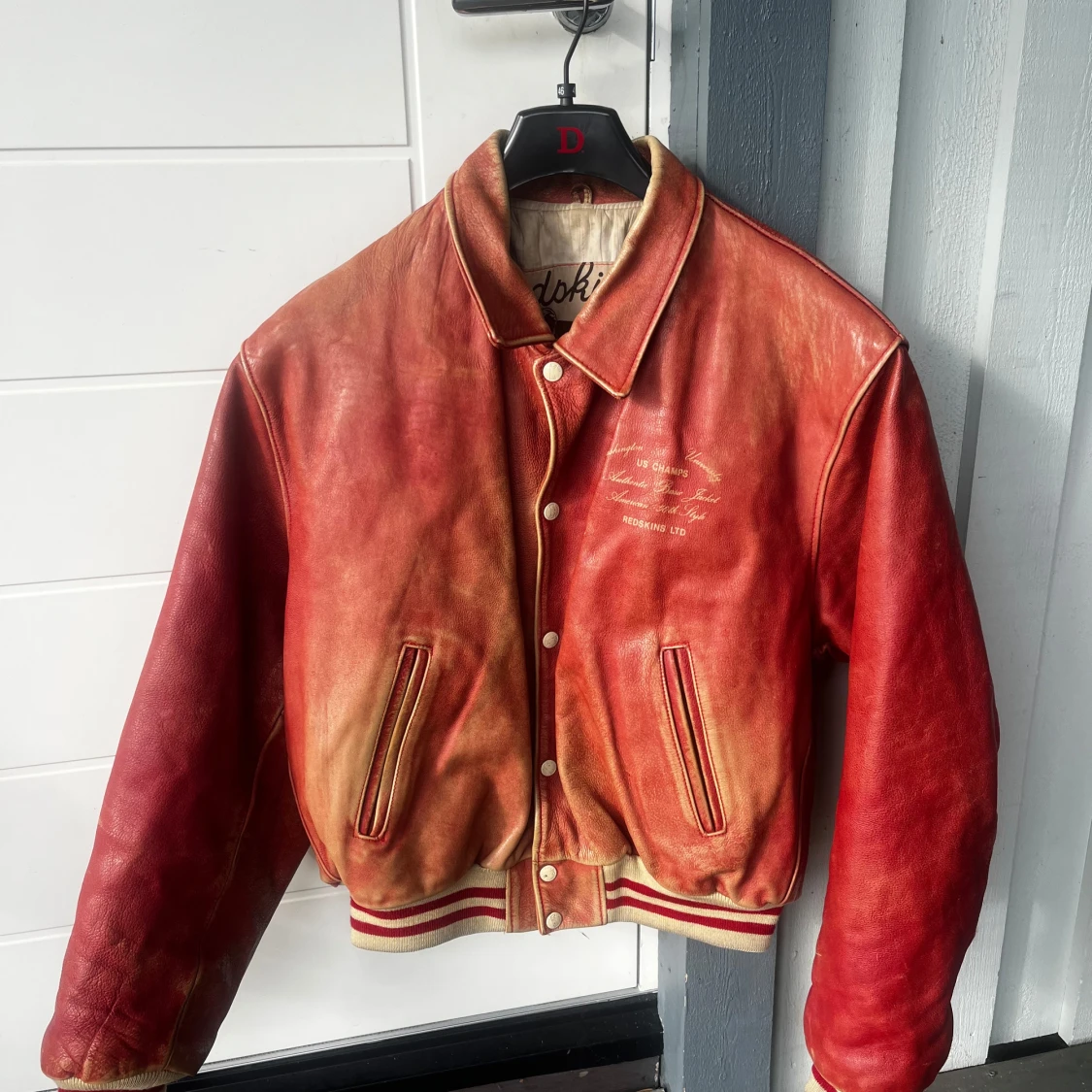 Röd skinnjacka med knappar från redskins