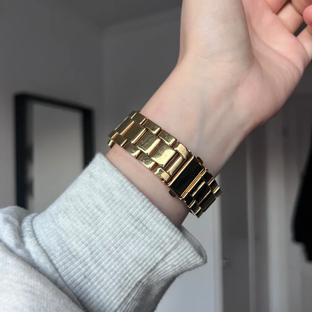 Snygg guldfärgad klocka från O.N.E med strass runt urtavlan och länkar. Urtavlan har flera små visare och en elegant design. Perfekt för att ge en touch av glamour till din outfit. Sparsamt använd. Extra länkar för att göra armbandet längre följer med. Önskar du veta exakta mått? Tveka inte att höra av dig!. Asusteet.