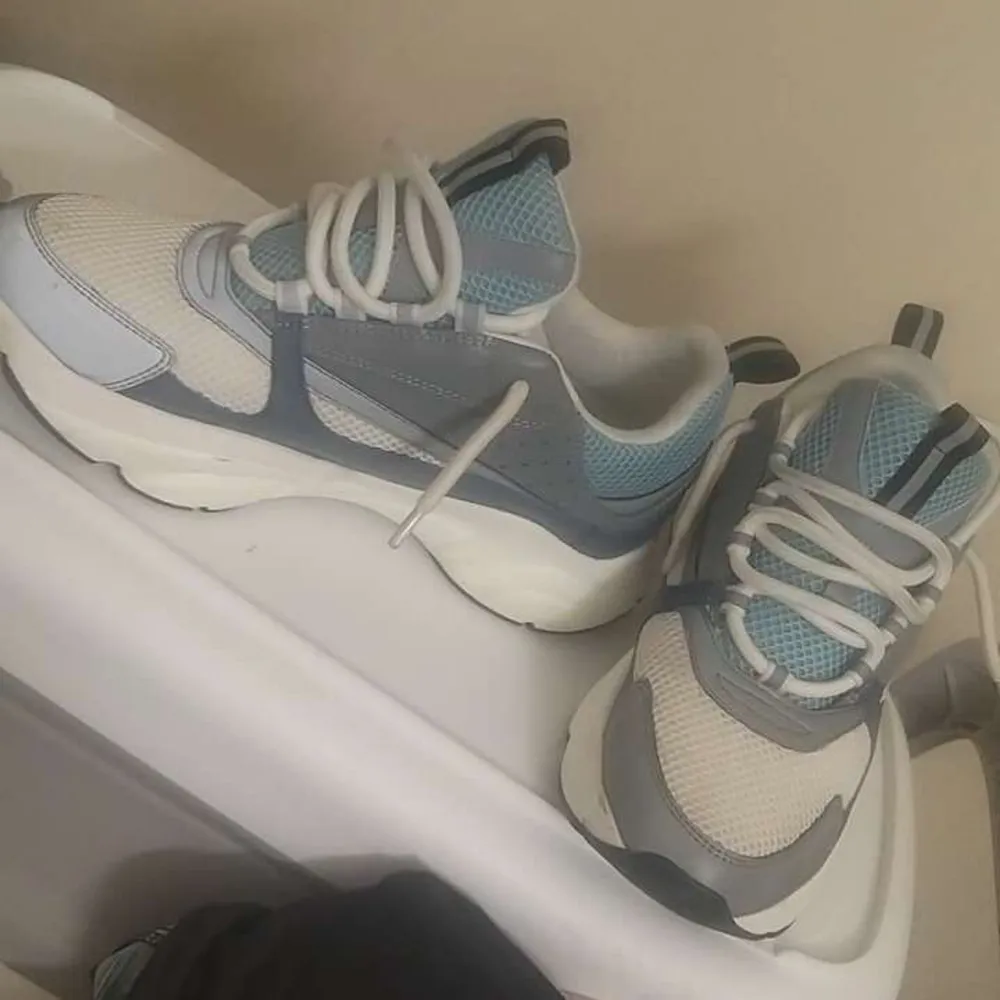 Har bara använt den i 2/3 veckor säljer dem eftersom jag.. beställde fel storlek. snygga sneakers från Dior i en stilren design med vita, grå och blå detaljer. Skorna har snörning och en bekväm passform, perfekt för en trendig look. . Kengät.