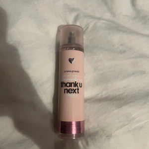 Ariana Grande Thank U Next Body Mist - Säljer en body mist från Ariana Grande med doften Thank U Next. Flaskan är rosa med ett hjärta på framsidan och har en praktisk sprayfunktion. Perfekt för att fräscha upp sig med en söt och fruktig doft. Använd max 5 gånger. Luktar exakt som parfymen och är jättestark