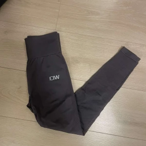 Gråa träningstights från ICANIWILL - Snygga gråa träningstights från ICANIWILL. Perfekta för träning med sitt stretchiga och bekväma material. Diskret logga på benet och midjan ger en stilren look. De har gått upp en remsa där bak på tightsen, men de är lagade och inget man ser.