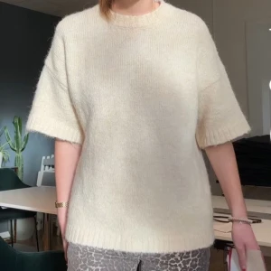 Stickad tröja - Säljer en mysig beige stickad tröja från nakd. Tröjan har korta ärmar och en rund halsringning. Perfekt för en avslappnad stil. Hör av dig vid intresse!