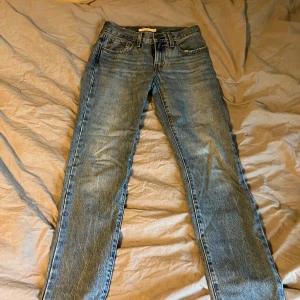 Blå jeansbyxor från Levi's - Säljer ett par klassiska blå Levi's jeans med rak passform. De har en dragkedja och knapp framtill samt fem fickor. Perfekta för en avslappnad stil. Använda ett fåtal gånger, nypris 1200 kr. Storlek är 24 vilket motsvarar ungefär xs