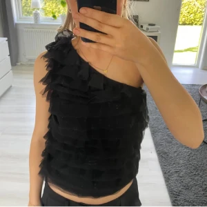 Svart oneshoulder topp från Stockh LM Studio - Jätte söt topp med volang från STOCKH LM som jag köpte till nyår! Bara använd en gång ( nyårsafton) men är i gott och ny skick! Tror jag köpte för ca 1000kr så dämed priset! 💞☺️ Köpt på plick men säljer vidare 💕💕