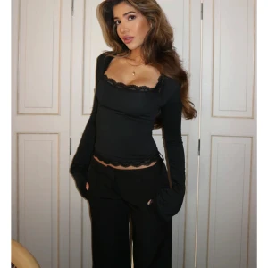 Venderbys topp - Snygg svart långärmad topp med spetsdetaljer vid halsringning och nederkant. Perfekt för en stilren look. Tröjan är oanvänd och den är slutsåld på hemsidan