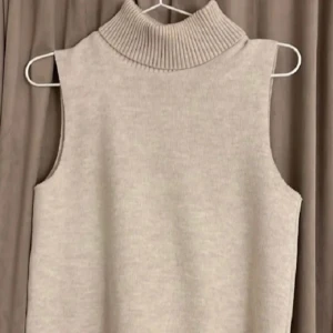 Beige ärmlös polotröja från Zara - Säljer en jätte snygg stilren beige ärmlös polotröja med ribbad krage. Säljs då den ej kommer till användning 🥰 Från Zara! 