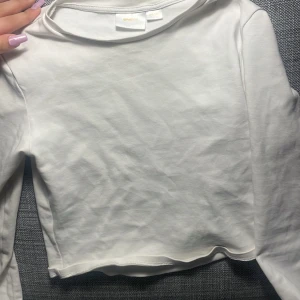 Vit långärmad topp från Gina Tricot - Säljer en stilren vit långärmad topp från Gina Tricot. Perfekt för en enkel och snygg look. Toppen är i en mjuk och bekväm bomullsmix. Passar bra till både jeans och kjol. Hör av dig vid intresse! 🤍