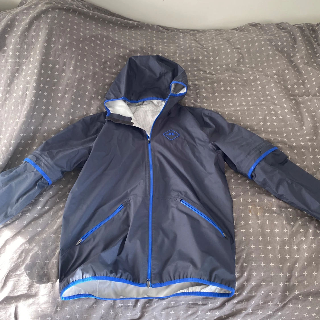 Grå regnjacka med blå detaljer