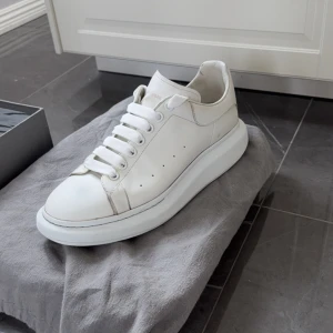 Vita sneakers från Alexander McQueen - Snygga vita sneakers från Alexander McQueen med en hög sula och klassisk snörning. Perfekta för en stilren look. Storlek 44, hör av er vid frågor mvh Oscar 