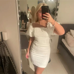 Vit klänning med puffärmar - Säljer en superfin vit klänning med puffiga kortärmar och en tight passform. Klänningen har en texturerad yta som ger den en unik look. Perfekt för sommarens alla tillfällen! 💫aldrig använd
