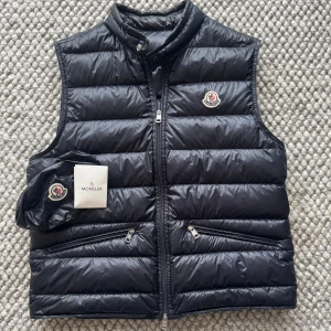 MONCLER GUI VÄST - Moncler gui väst - Size 3 sitter som M - Skick 10/10 - Påse samt extra knappt tillkommer - Nypris 9200 - deluxecloset