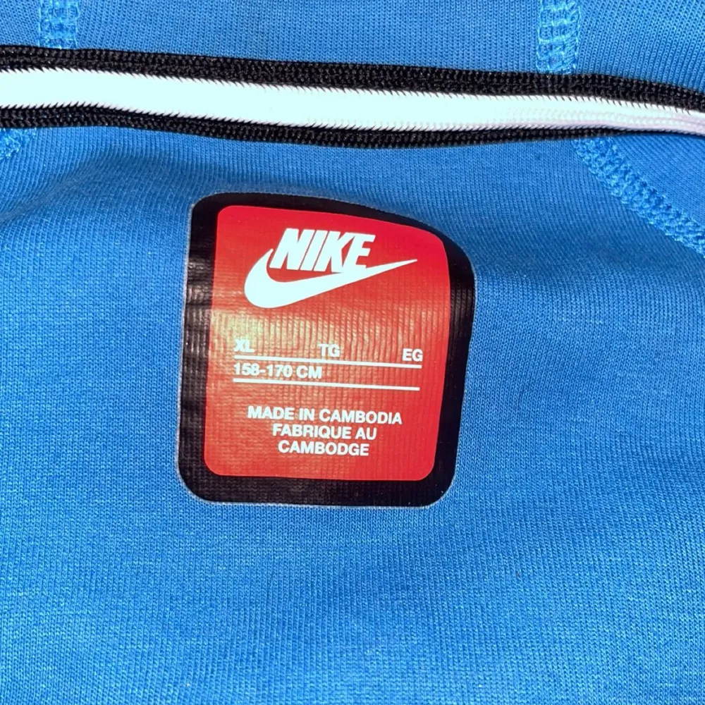 Snygga blå mjukisbyxor från Nike med svart logga på benet. Byxorna har en bekväm passform med snörning i midjan och praktiska fickor med dragkedja. Perfekta för en avslappnad stil. Ljuset i värkligheten än på fotorna. Använd 1-3 gånger på grund av att den var för lite. Storlek Xl i barn motsvarar S (158-173. Neuletakit & Villapaidat.