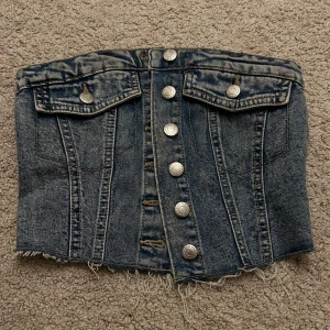 Jeans topp  - Jeans topp i storlek XS använd fåtal gånger. Lätt att knäppa och på 3e bilden så ser man att den är stretchig och går även att användas som S eller ha bh under. Klippt av lapp inuti, Fint skick 