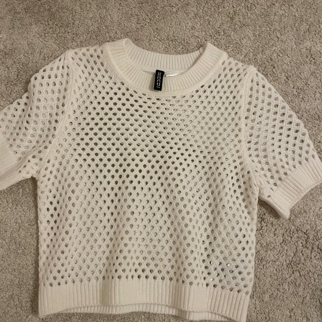 Stickad kortärmad tröja med ”hål” i