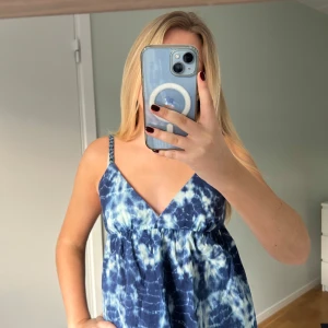 Tie dye mönstrad topp - Snygg blå tie dye topp med smala axelband och v-ringning. Perfekt för sommardagar, toppen har en luftig passform.