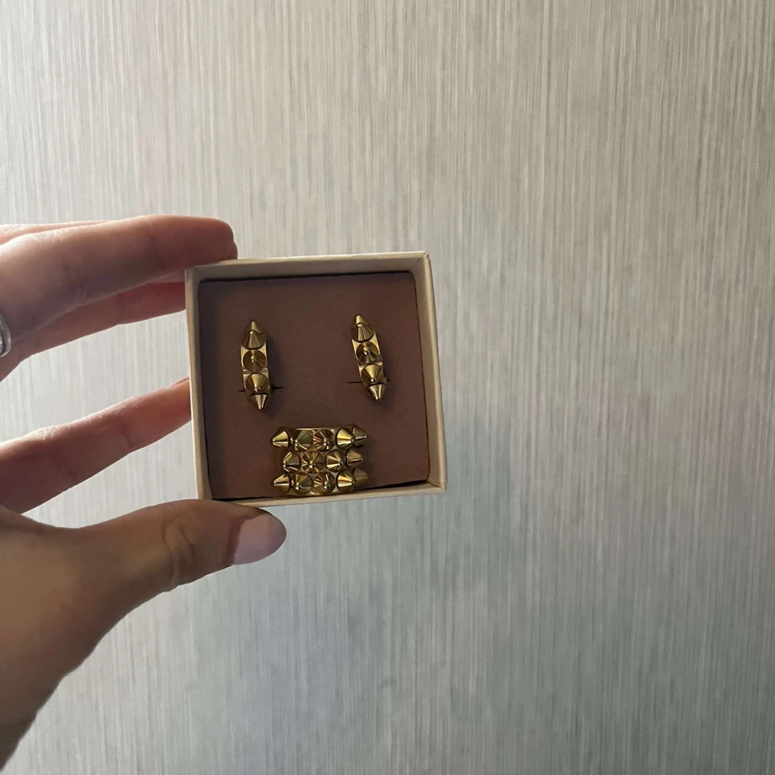 Guldpläterade smycken med nitar