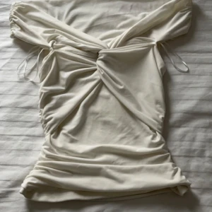 Vit blus från BikBok - Säljer en stilren vit blus från BikBok i storlek XS. Blusen har en omlott-design med knytning och offshoulder-ärmar. Perfekt för en somrig look! Pris kan diskuteras vid snabb affär💕
