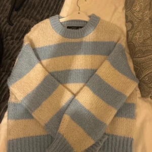 Randig stickad tröja från Vero Moda - Mysig stickad tröja från Vero Moda i ljusblått och beige. Använd fåtal gånger