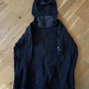 Svart hoodie från C.P. Company - Säljer min killes svart hoodie från C.P. Company, den är storlek M och passar folk runt 180cm. Väldigt bra skick. Finns att hämtas ifrån honom i stockholm.